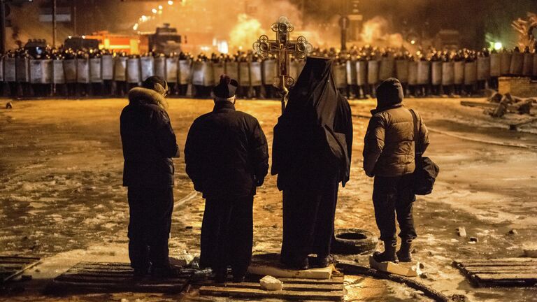 Священнослужители стоят между милицией и оппозицией на нейтральной территории, для предотвращения столкновений