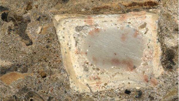 Сделанный при помощи микроскопа снимок фрагмента отложений на месте очага, где среди пепла есть обгоревшая кость и мелкие камни из почвы