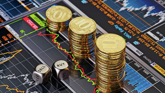 Стопки десятирублевых монет на экране с биржевыми графиками. Архивное фото