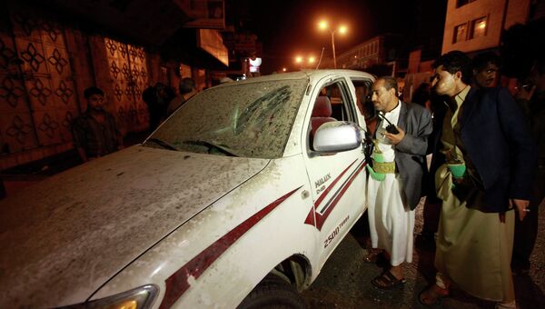 Полицейские осматривают автомобиль, поврежденный взрывом рядом с резиденцией экс-президента Йемена Али Абдаллы Салеха. Фото с места событий