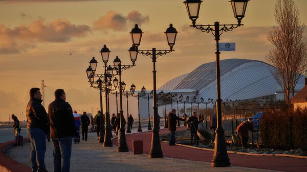 Горожане и туристы гуляют по набережной Черного моря в Сочи