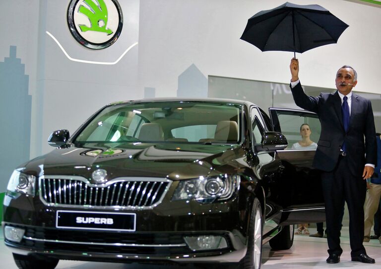 Управляющий директор Skoda Auto в Индии показывает зонтик, который устанавливается на задней панели двери Skoda Superb во время Auto Expo 2014 в Нью-Дели, Индия