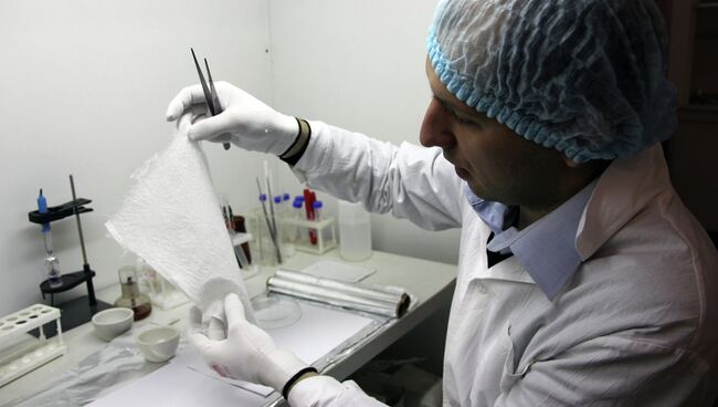 Научный сотрудник лаборатории биосовместимых материалов ТПУ Евгений Больбасов держит в руках нетканые матриксы для замещения кожных покровов и регенеративной медицины