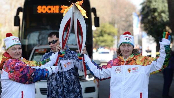 Руководитель пресс-службы Оргкомитета Сочи-2014  Евгения Бочарникова (справа) во время эстафеты Олимпийского огня в Сочи.