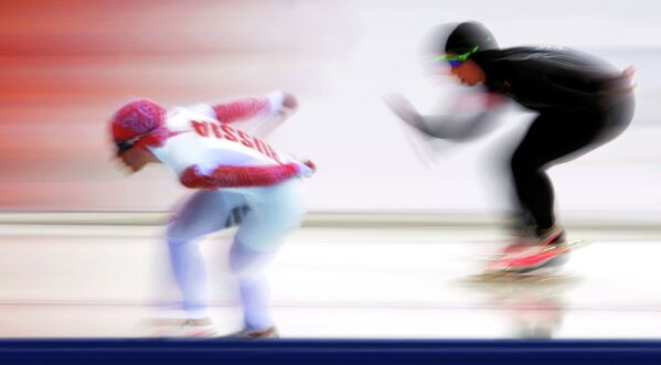 Ольга Граф (Россия) (слева) и Джиллиэнн Рукард (США) на дистанции в забеге на 3000 метров в соревнованиях по конькобежному спорту среди женщин