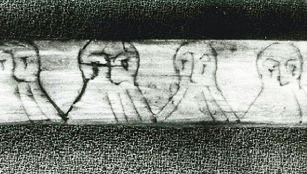 В этой надписи зашифрованные руны спрятаны в бородах нарисованных мужчин