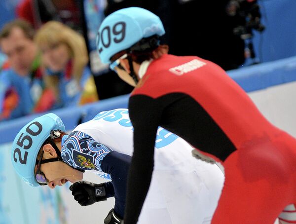 Виктор Ан (Россия) и Тянью Хань (Китай) в полуфинале эстафеты на 5000 метров в соревнованиях по шорт-треку среди мужчин на XXII зимних Олимпийских играх в Сочи