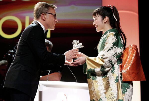 Кристоф Вальц вручает награду японской актрисе Хару Куроки во время церемонии награждения победителей 64-го Берлинале