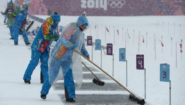 Сотрудники комплекса для соревнований по лыжным гонкам и биатлону Лаура перед началом гонки с масс-старта в соревнованиях среди мужчин на XXII зимних Олимпийских играх в Сочи