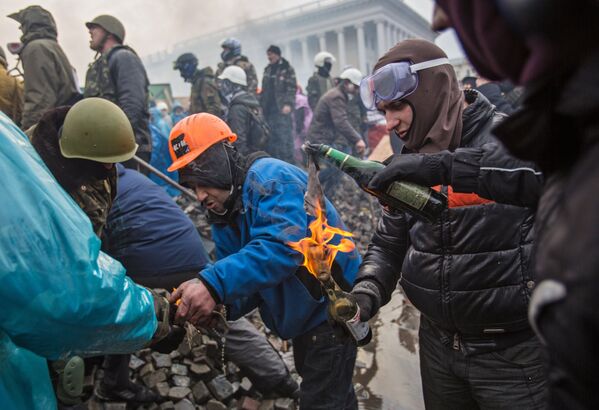 Сторонники оппозиции поджигают бутылки с зажигательной смесью на площади Независимости в Киеве