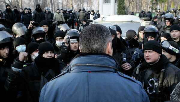 Лидер украинской оппозиции Виталий Кличко разговаривает с сотрудниками внутренних войск за пределами здания парламента в Киеве.  Фото с места события