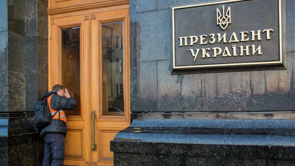 Мужчина заглядывает через стекло двери в здание администрации президента Украины в центре Киева. Милиция покинула территорию правительственного квартала