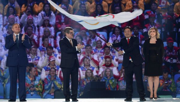 Президент Международного олимпийского комитета Томас Бах передает Олимпийский флаг мэру города Пхенчхана. Архивное фото