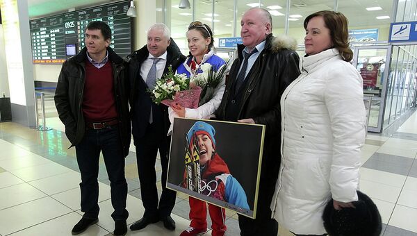 Российская биатлонистка Ольга Вилухина (в центре) в аэропорту Толмачево