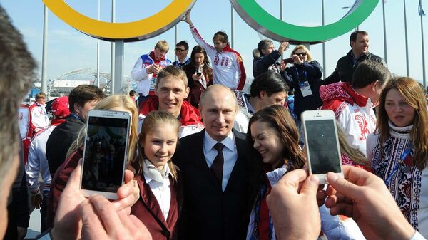 Президент России Владимир Путин во время церемонии фотографирования с российскими призерами XXII зимних Олимпийских игр в Сочи. 24 февраля 2014