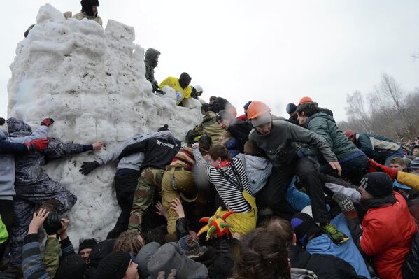 Посетители масленичных гуляний участвуют штурме снежной крепости на праздновании Бакшевской масленицы в Московской области.