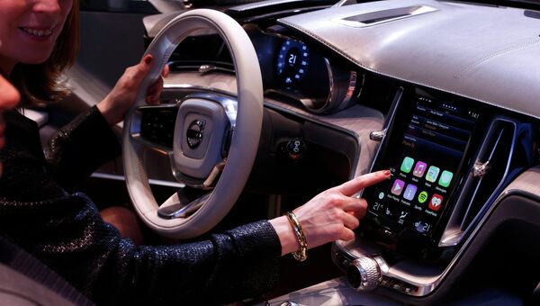 Женщина демонстрирует дисплей с функцией CarPlay на автосалоне в Женеве. Фото с места события