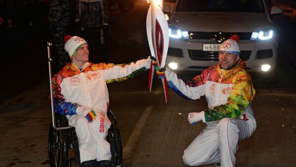 пауэрлифтер Владимир Кривуля (слева) во время эстафеты Олимпийского огня в Краснодаре.