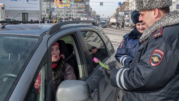 Сотрудники ГИБДД поздравили букетами цветов новосибирских автоледи, событийное фото