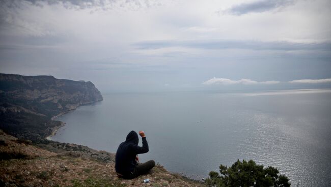 Молодой человек на скалистом побережье Черного моря. Архив