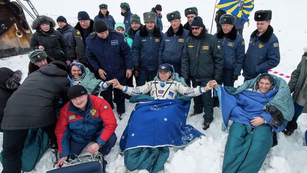 Космонавты корабля Союз ТМА-10М после посадки в казахстанской степи