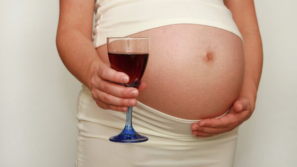 Беременная женщина с бокалом вина