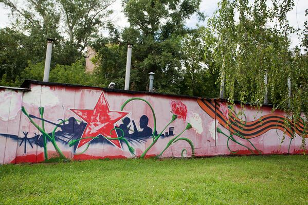 Граффити вдоль бетонного забора рядом с гаражами по улице Речников на юге Москвы