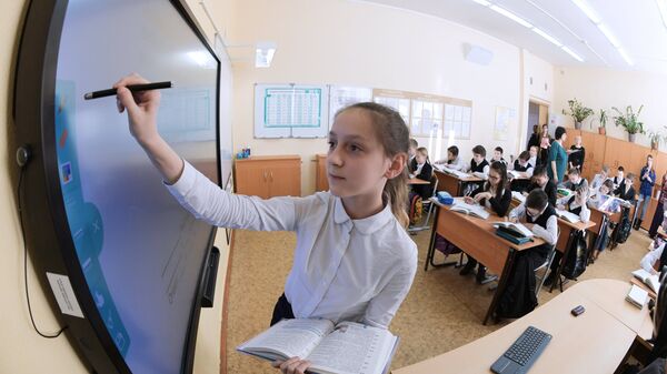 Ученица выполняет задание возле интерактивной доски