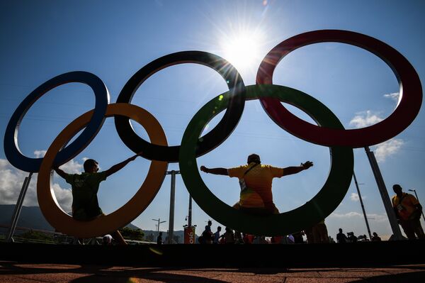 Отдыхающие фотографируются у олимпийских колец в олимпийском парке в Рио-де-Жанейро