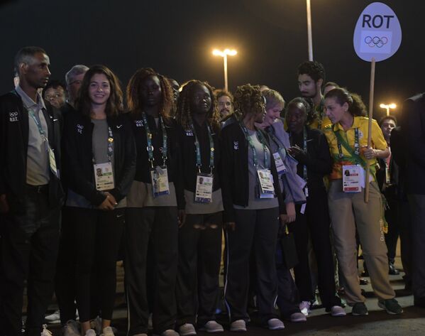 Спортсмены олимпийской команды беженцев на торжественной церемонии поднятия флагов в олимпийской деревне