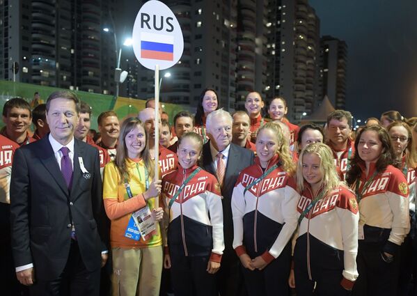 Александр Жуков (слева) и Виталий Смирнов (в центре) на торжественной церемонии поднятия флагов в олимпийской деревне