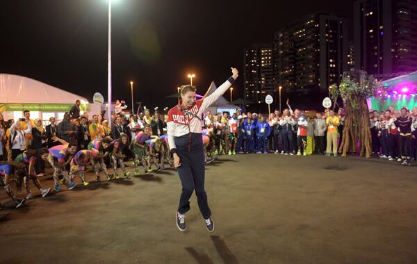 Российская волейболистка Ирина Заряжко танцует на торжественной церемонии поднятия флагов в олимпийской деревне