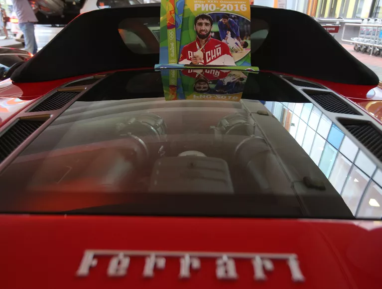Автомобиль Феррари с плакатом с изображением российского дзюдоиста Хасана Халмурзаева Автомобиль Феррари с плакатом с изображением российского дзюдоиста Хасана Халмурзаева