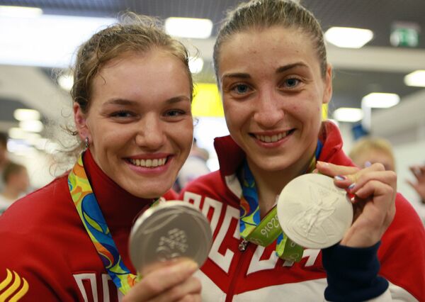 Дарья Шмелева (справа) и Анастасия Войнова, завоевавшие серебряные медали ОИ-2016 в Рио, в аэропорту Шереметьево