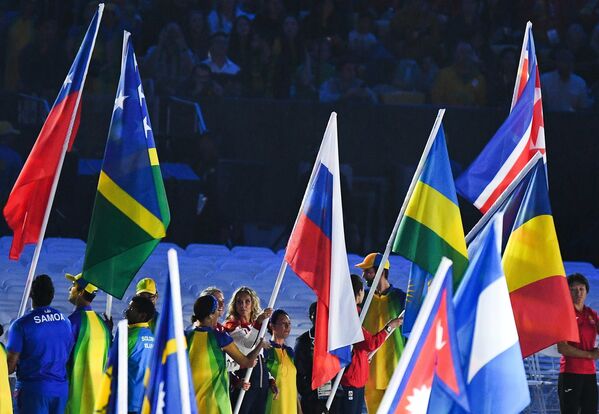 Светлана Ромашина и Наталья Ищенко (в центре слева направо) с российским флагом на церемонии закрытия XXXI летних Олимпийских игр в Рио-де-Жанейро