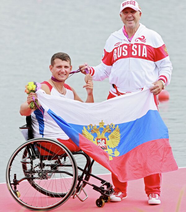 Российский спортсмен Алексей Чувашев, завоевавший бронзовую медаль, с личным тренером Валерием Бисарным на церемонии награждения на Паралимпийских играх 2012 в Лондоне