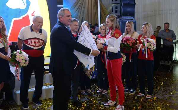 Дмитрий Рогозин (на первом плане) приветствует женскую сборную России по гандболу во главе с главным тренером команды Евгением Трефиловым (в центре)