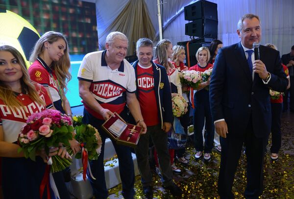 Дмитрий Рогозин (на первом плане) приветствует женскую сборную России по гандболу во главе с главным тренером команды Евгением Трефиловым (третий слева)