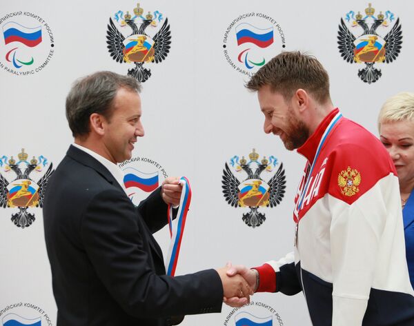 Заместитель председателя правительства РФ Аркадий Дворкович (слева) награждает паралимпийца Сергея Малышева