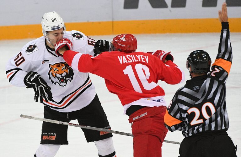 Нападающий ХК Амур Данил Романцев, нападающий ХК Спартак Александр Васильев и главный судья матча Конц Даниэль (слева направо)