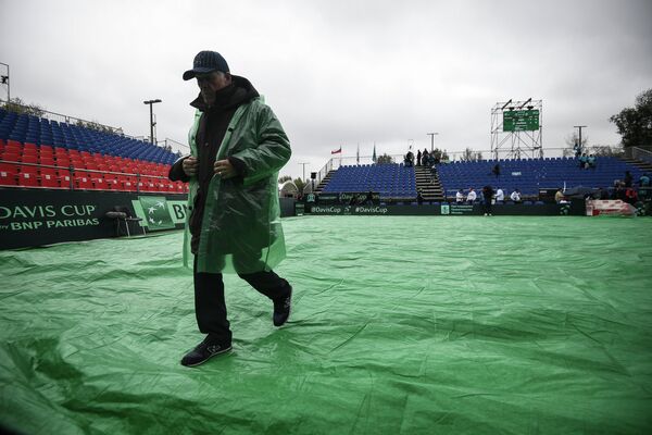 Сотрудник на корте Национального теннисного центра в Москве во время матча Кубка Дэвиса