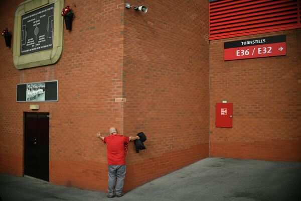 Болельщик Манчестер Юнайтед возле одной из стен стадиона Олд Траффорд