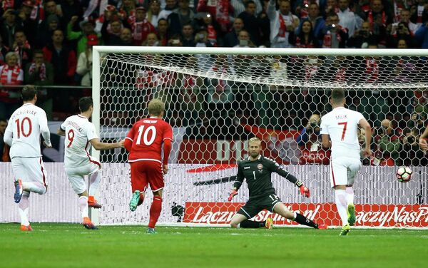 Форвард сборной Польши Роберт Левандовский (второй слева) забивает гол в ворота команды Дании