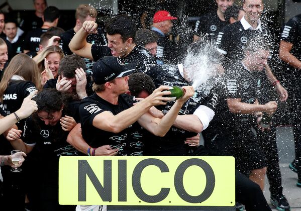Пилот Мерседеса немец Нико Росберг (в центре) после победы в гонке 17-го этапа чемпионата Формулы-1 - Гран-при Японии