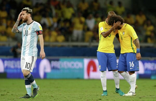 Нападающий сборной Аргентины Лионель Месси и футболисты сборной Бразилии Фернандиньо и Марсело (слева направо)