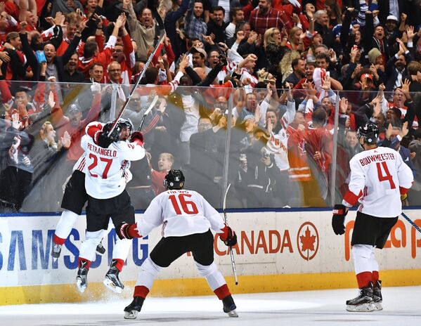 Хоккеисты сборной Канады радуются заброшенной шайбе, принесшей победу в финальном матче Кубка мира по хоккею