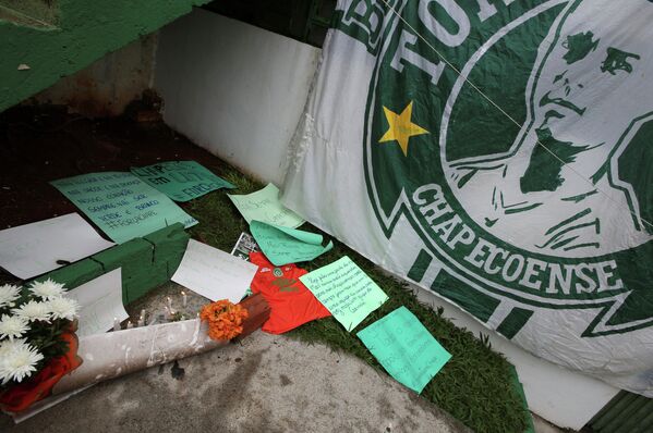 Цветы и записки рядом с флагом футбольного клуба Шапекоэнсе