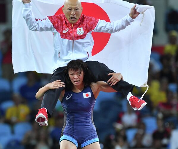 Рисако Каваи (Япония) с главным тренером сборной Японии по борьбе Кадзухито Сакаэ на плечах радуется победе в финале Олимпийских игр