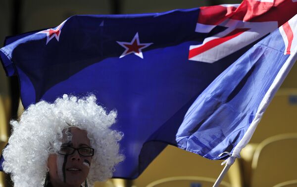 Флаг Новой Зеландии в руках футбольной болельщицы