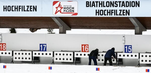 Служащие меняют мишени на стрельбище во время тренировки перед началом чемпионата мира по биатлону в Австрии